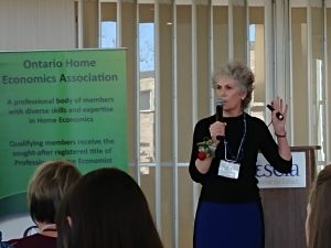 Carol in front of Ontario Home Economics Association banner